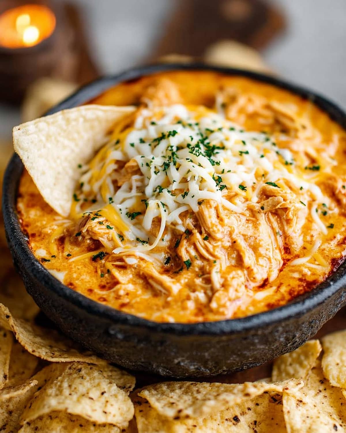 Crock Pot queso chicken, topped with melted cheese and fresh herbs.