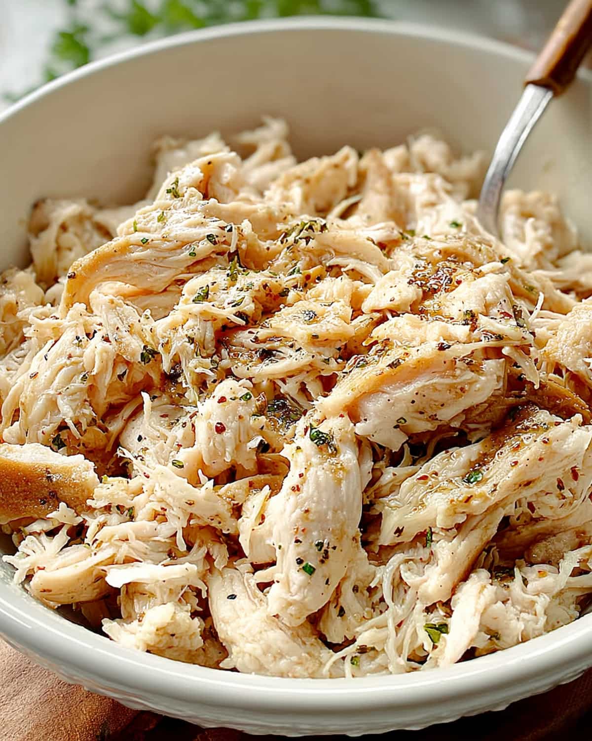 Frozen chicken in Crock Pot cooked tender with herbs and seasonings.