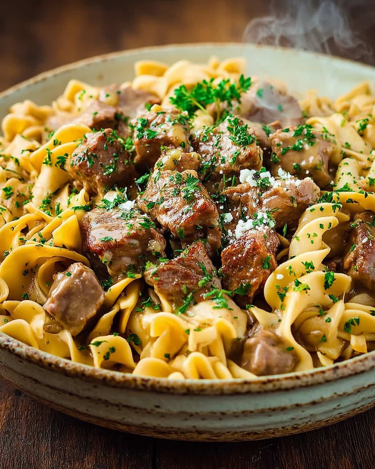 Slow Cooker beef and noodles, with tender beef pieces in a creamy sauce served over noodles.