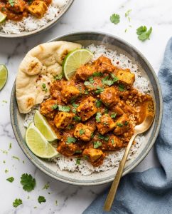 Slow Cooker Chicken Tikka Masala served over rice with creamy tomato sauce and cilantro, close-up in a bowl